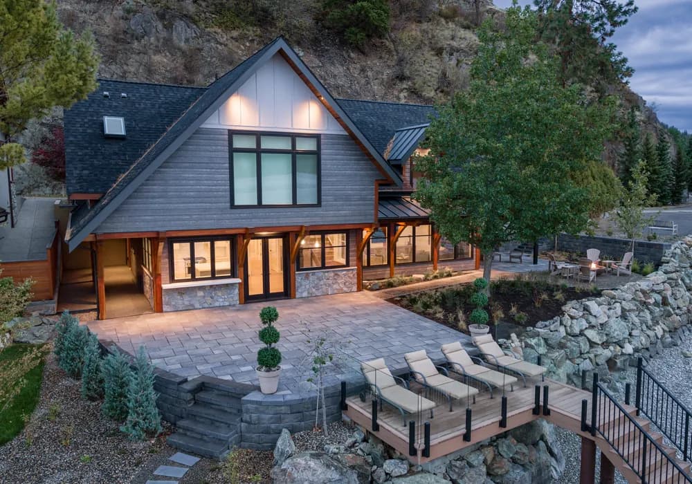 lake front home with stairs and shrubs