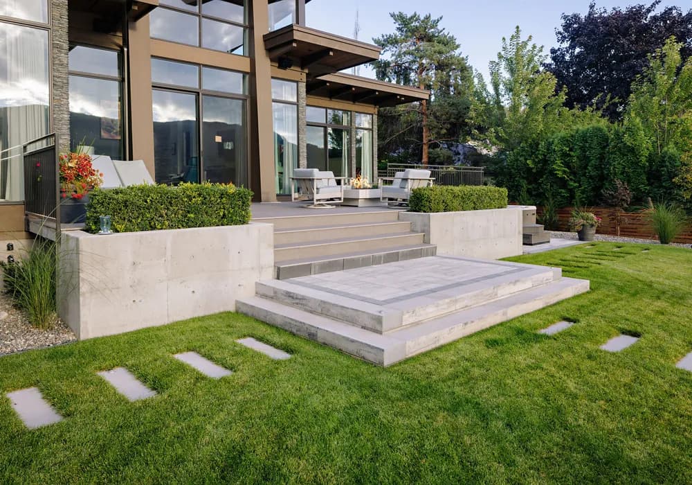 modern home and retaining wall and shrubs and trees