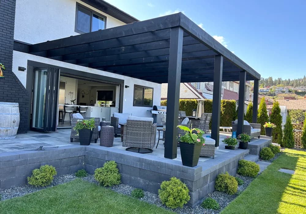 pragola with shrubs and patio and wall of stone