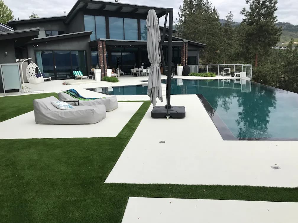 Artificial turf and a view of a modern home and a pool