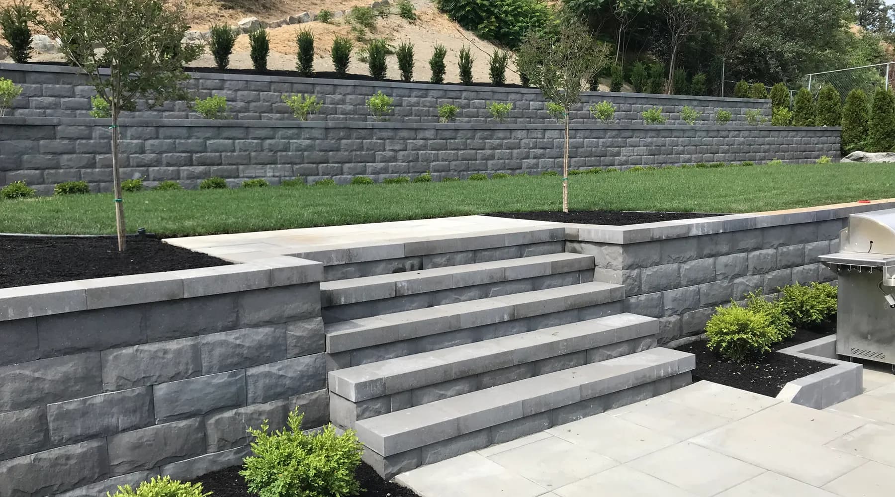 paver stone flooring green yard and retaining wall