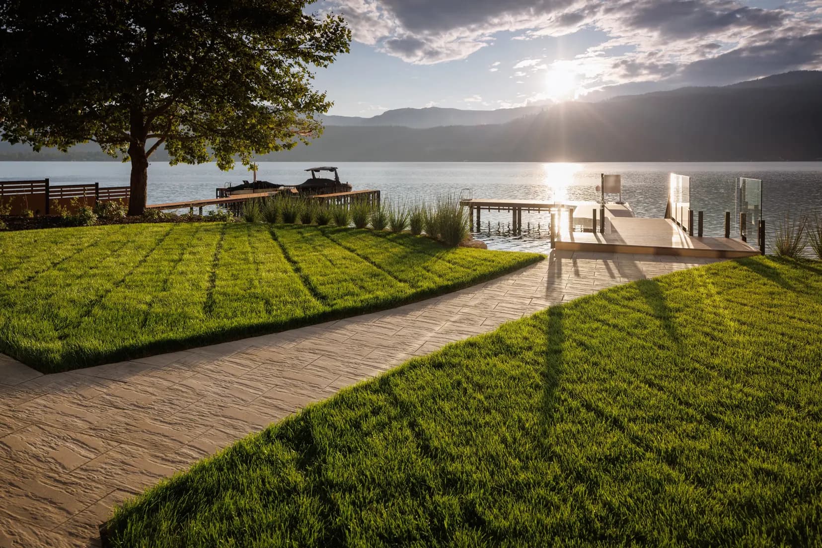 Turf on a lakefront property with a view of the lake and mountains